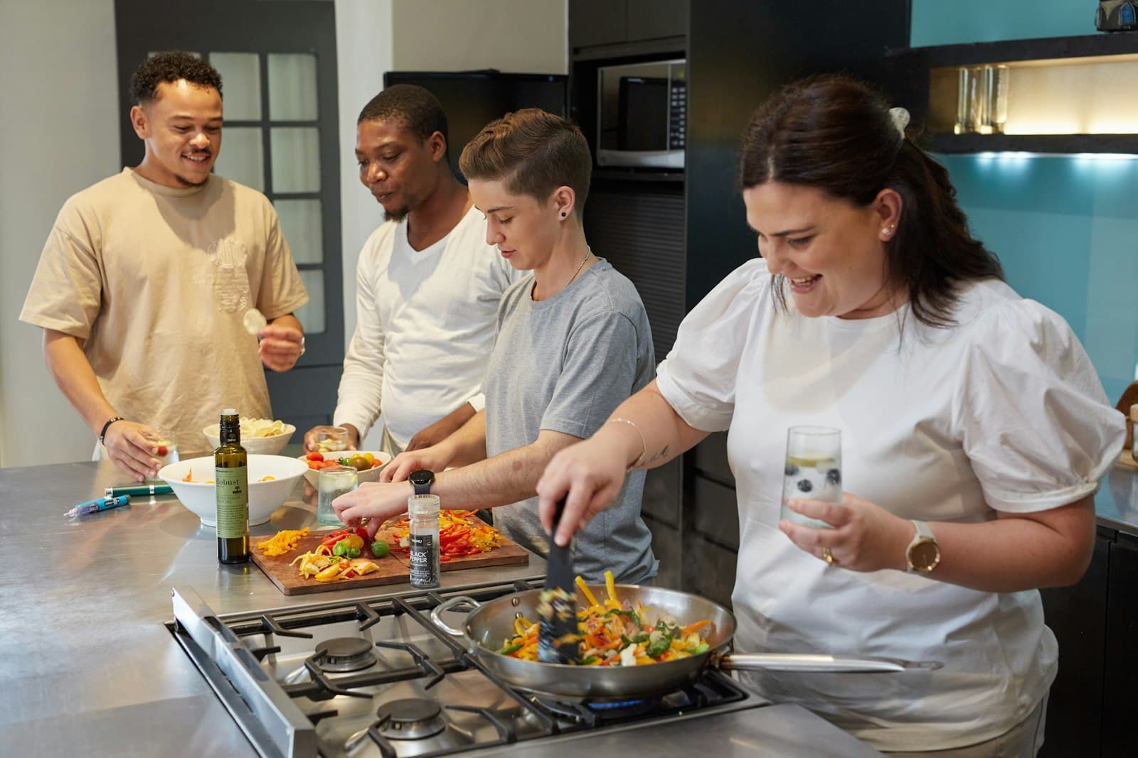 Adults cooking a meal together at a shared kitchen stove